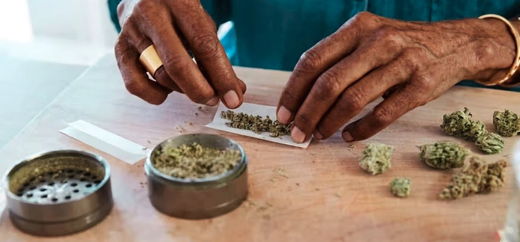 Hands carefully preparing flower while following tips for using terpenes safely and effectively, focusing on dose control and maintaining cannabis product quality through proper handling